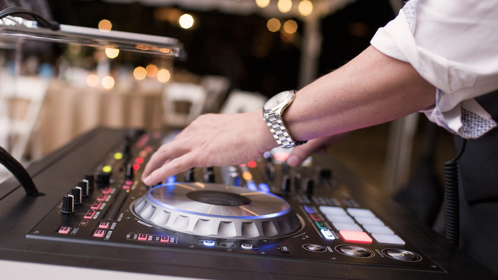 Hands adjusting a DJ controller during an event